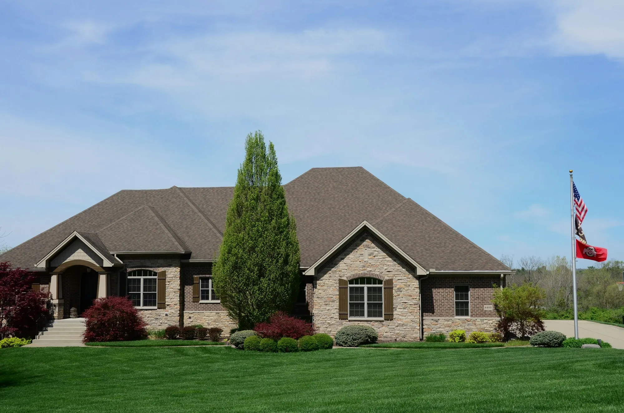 Brick ranch house with a flag pole in the front yard